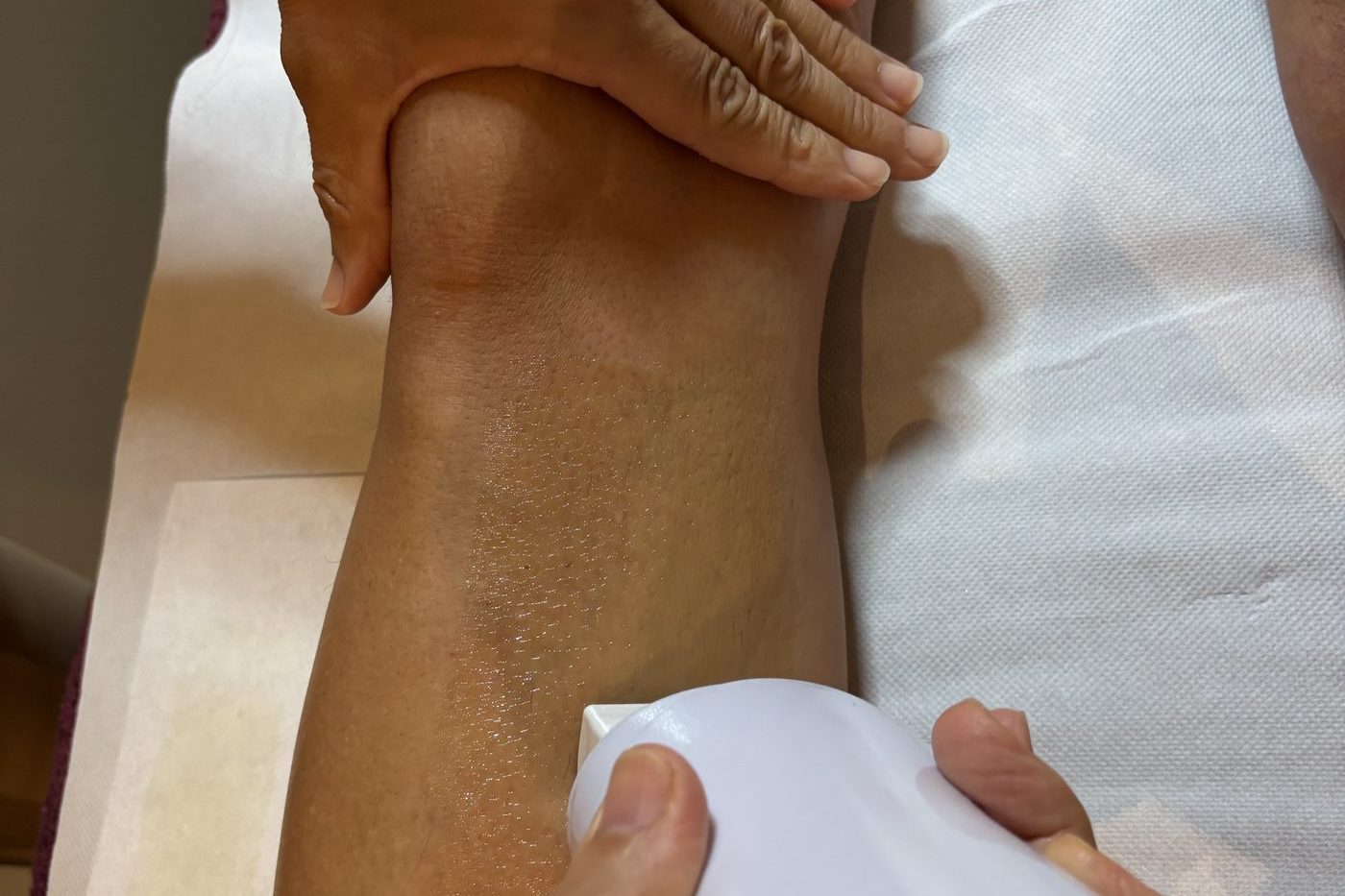 Épilation au roll-on de cire au miel sur la jambe, institut Coeuroline à La Seyne-sur-Mer